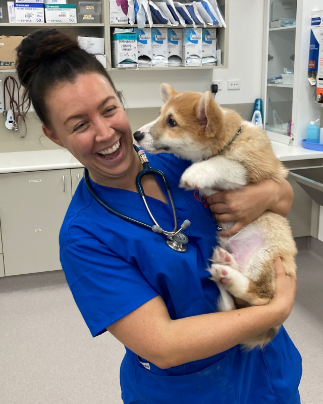 Emergency Vet holding a puppy while it kisses her face